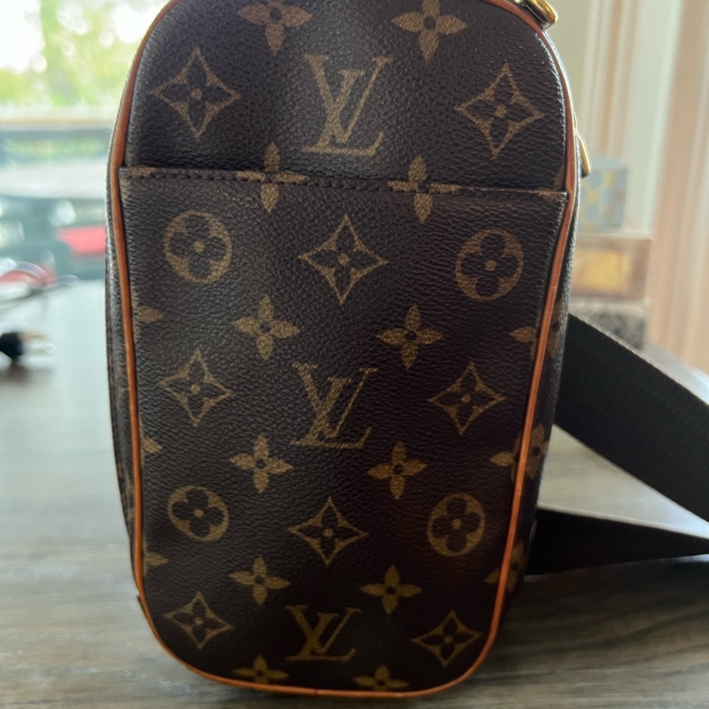 This Louis Vuitton Monogram Pochette Gange Bag features a Brown CoatedWaterproof